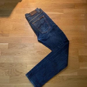 Nudie jeans (Grim Tim) 30/32 Blå - Säljer ett par klassiska slim fit blå jeans från Nudie Jeans. Storlek W30 L32 men skulle passat till dig ifall du har en mindre storlek. Bra skick utan hål eller defekter men väldigt små tecken på användning finns. Hör bara av er om ni har frågor! 