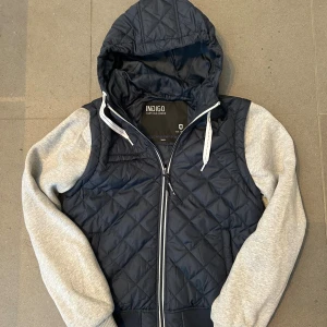 Mörkblå cardigan - Säljer en snygg mörkblå cardigan i storlek S!  Ärmarna går att enkelt ta av med en dragkedja som inte syns vid armen. Modellen är rätt lång i ärmarna. Öppen för frågor