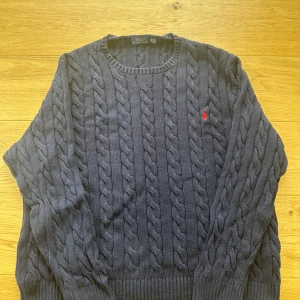 Mörkblå kabelstickad tröja Polo Ralph Lauren - Fin tröja från märket polo ralph lauren   Mått: Längd 68 cm, bredd 51 cm Rökfri: Ja Storlek: XXL Skick: Väldigt bra ser ny ut Frakt: skickas samma dag innan 20:00 Hör av er vid minsta fundering så svara jag på det inom 10 minuter.