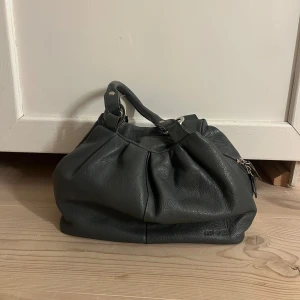 Snygg handväska - Tre innerfack, sparsamt använd. Finns något spår av användning, ses sista bilden, annars bra skick!!