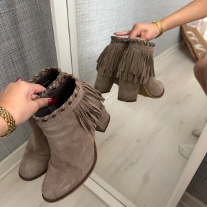 Beige mockaboots med fransar - Snygga boots i beige mocka med chunky klack och coola fransdetaljer runt skaftet.  Skjut coola beiga boots som passar perfekt till hösten och många olika outfits🤍