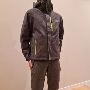 Grå skidjacka och skidbyxor från Swedemount - Säljer en grå skidjacka och skidbyxor från Swedemount med limegröna dragkedjor och detaljer. Jackan har huva, flera fickor med blixtlås, även för liftkort. Både byxor och jackan är vind- och vattentät till 8000mm. Knappt använda.