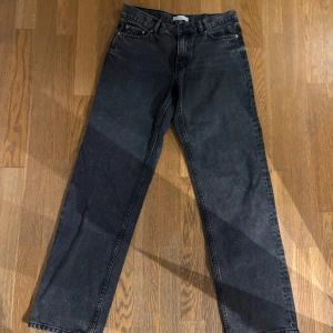 Svarta straight jeans från Gina Tricot - Snygga svarta jeans från Perfect Jeans i rak modell. Jeansen har klassisk femficksdesign, bälteshällor och knappgylf. Materialet är robust denim som ger en cool vibe till outfiten. Perfekta för dig som gillar en enkel och stilren look.