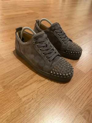 Christian Louboutin skor - Gråa Christian Louboutin skor i väldigt bra skick. Skorna har väldigt lite healdrag. Storlek 42 kan även passa 43. Tveka inte att kontakta vid minsta lilla fundering.