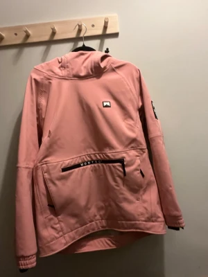 Rosa vindjacka från Montec med huva - Säljer en snygg rosa skidjacka från Montec med stor huva och dragkedja framtill. Jackan har en stor ficka med svart dragkedja och Montec-logga på bröstet och ärmen. Köpte jackan för 1200kr