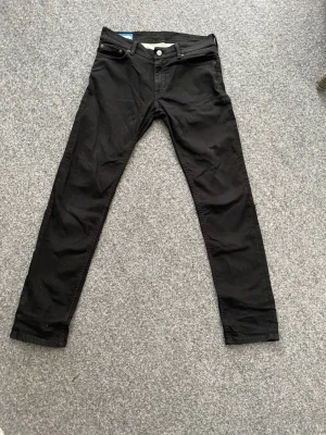 Svarta skinny jeans från Acne Studios - Säljer ett par svarta jeans från Acne Studios Blå Konst, tillverkade i Italien. Modellen har smal passform med klassisk femficksdesign och knappgylf. Materialet är mjukt och slitstarkt, perfekt för dig som gillar stilrena och moderna jeans. W29 L30
