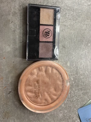 Revolution Highlighter & NOFO Ögonskuggspalett - Säljer en Revolution Highlighter Reloaded 'Just My Type' i en skimrande champagne-nyans med vågig yta, samt en NOFO Nordic Formula ögonskuggspalett med tre metallicfärger: guld, rosa och taupe. Båda kommer i smidiga plastförpackningar.