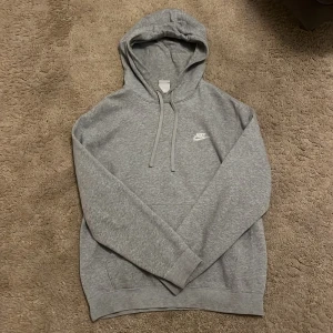 Grått Nike mjukis set - Säljer ett grått Nike mjukis set. Tröjan har snörning och en logga på bröstet. Inga skavanker på den alls. Byxorna har också snörning och logga på ena lårsidan utan skavanker. Ett väldigt snyggt och skönt set som är perfekt nu inför vintern. Det har inte förbrukats så extremt mycket så de är i ett bra skick. OBS Säljer hela setet tillsammans! Om ni även vill ha fler bilder på setet så är det bara att höra av sig!