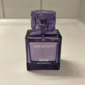 OMR Beauty Intro Eau de Parfum - Trendig parfym från OMR Beauty med modern design. Perfekt för dig som vill sticka ut med en stilren och snygg flaska. Namnet 'Intro' ger en hint om en fräsch och ungdomlig vibe.
