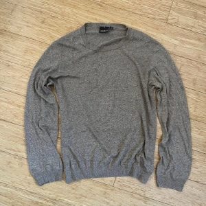 Beige stickad tröja Oscar Jacobson M - Snygg beige stickad tröja från Oscar Jacobson, tillverkad i Italien. Tröjan har rund hals, ribbade muddar och långärmad passform. Mjuk och tunn i 100% bomull. Mått: 56 cm över bröstet och 62 cm ärmlängd. Hör gärna av dig vid frågor!