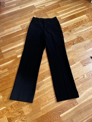 Svarta kostymbyxor från Lindex - Superfina svarta kostymbyxor från Lindex med raka ben. Snygg och stilren modell i ett mjukt material. Storlek 164 men passar xs/s. Prislappen är inte kvar men byxorna är aldrig använda. 