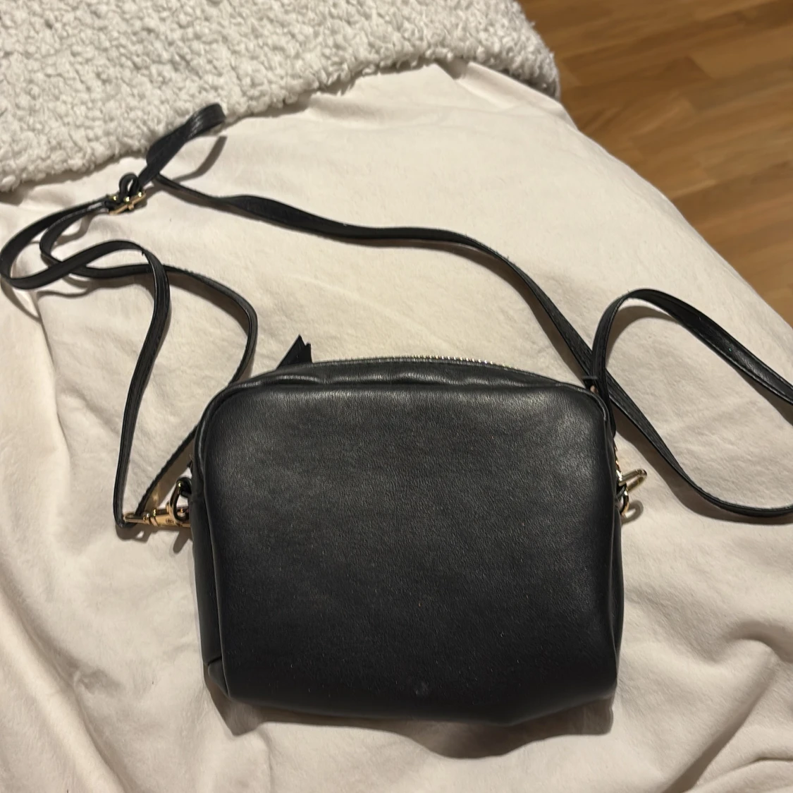 Svart axelväska i skinn med gulddetaljer