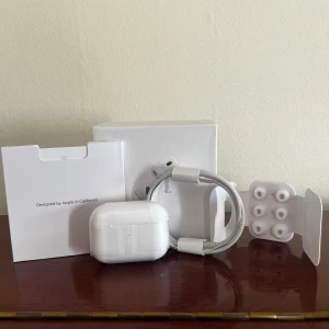 AirPods Pro (2nd generation) - Säljer ett par AirPods Pro (2nd generation) i nyskick, USB-C, komplett med originalförpackning, laddningskabel och extra öronkuddar. Inga synliga defekter eller slitage, allt ser ut som nytt. Perfekt för dig som vill ha aktiv brusreducering och hög ljudkvalitet. Köptes i början på april, i hopp om att dem skulle komma till användning. I samma veva fick jag tag på ett par over-ear hörlurar, som jag använt mig utav istället. Nu ligger dessa bara och dammar. Hör av er vid frågor!