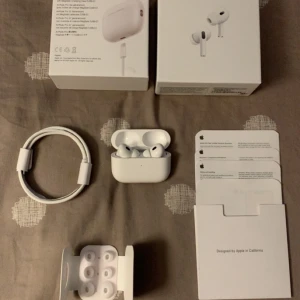 AirPods Pro 2 - Säljer ett par AirPods Pro 2 i nyskick med originalkartong, laddkabel, extra öronkuddar och dokumentation. Allt tillbehör medföljer. Pris kan diskuteras