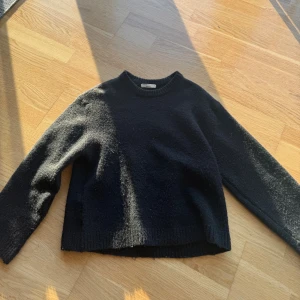 Svart stickad tröja från Gina Tricot - Mysig svart stickad tröja från Gina Tricot i storlek XS. Tröjan har rund halsringning, långa ärmar och en klassisk, enkel design som är lätt att matcha. Perfekt för kyliga dagar och passar till allt i garderoben.