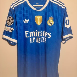 REAL MADRID TREDJETRÖJA 2025/26 - Tillverkad av adidas Originals, är denna tröja designad för att erbjuda både stil och prestanda på och utanför planen 🤝