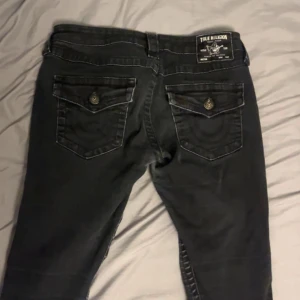 Svarta True Religion jeans bootcut - Svarta jeans från True Religion. De är i stilen joey. De är i bra skick, förutom att färgen på knapparna åker av lite men jag kan fixa det innan köp. Och tyget mellan låren är tunnare på grund av friktion. (Syns på sista bilden, gammal bild) Men inget som påverkar användningen 💕