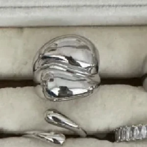 Chunky silverring med organisk form - Säljer en chunky silverring med cool, organisk och vågig design. Ringen har en blank yta och känns riktigt modern och edgy. Perfekt för dig som gillar statement-smycken och vill sticka ut lite extra.