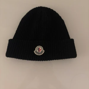 Moncler mössa - Snygg svart moncler mössa som är perfekt nu till vintern. Är i väldigt bra skick. Säljer eftersom att den inte används av mig.