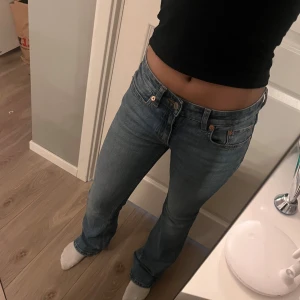 Blå bootcut jeans från 157 - Säljer ett par klassiska blå bootcut jeans från 157 med låg midja. Jeansen har en lätt utsvängd passform nertill. Tillverkade i jeansmaterial med en cool vintagekänsla. Perfekta för dig som gillar retrostil. Storlek xs