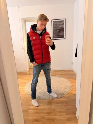 Röd moncler dunväst - Säljer nu min fina moncler väst. Den är storlek S och passar dig runt 170-182 ish. Qr koden funkar prima och serietidnings-tagen ser bra ut.