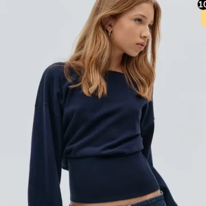 Marinblå stickad tröja med v-ringad rygg - Snygg marinblå stickad tröja med lång ärm och bred, ribbad midja. Tröjan har en cool v-ringad rygg och en rak halsringning fram. Perfekt för dig som gillar stilrena plagg med en twist. Passar till jeans eller kjol för en chill look.