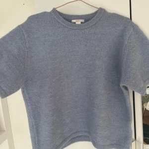 Ljusblå stickad tröja Gina Tricot - Supermysig ljusblå stickad tröja från Gina Tricot med kort ärm och rund halsringning. Perfekt för lager-på-lager och chill dagar. Mjuk och fluffig känsla, passar dig som gillar en enkel men stilren look.