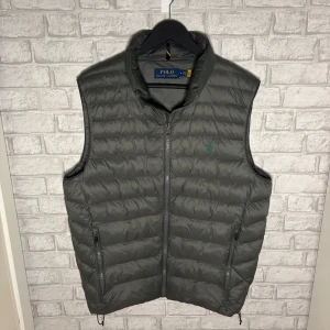 Ralph Lauren dunväst - Mörkgrön dunväst i nytt skick, använd endast en gång. Stilren och lätt modell med dragkedja och broderad logga. Hör av dig vid intresse 🙌