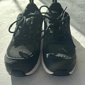 Svarta sneakers från Portwest strl 38 - Svarta sneakers från Portwest med mesh-överdel och detaljer i neongrönt. Skorna har snörning och vit sula med svart kant. Perfekta för dig som gillar sportig stil och vill ha bekväma skor till vardagen.