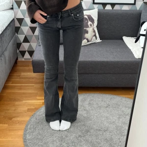 Mörkgrå/svarta bootcut jeans - Säljer ett par snygga mörkgrå/svarta jeans med bootcut-modell. De är lågmidjade, full length från lager 157. Jag är 169 lång och de går ner till marken!