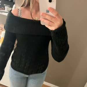 Svart offshoulder stickad tröja - Säljer en super mysig svart offshoulder tröja från hm🥰 den är i storlek m men sitter som en small och passar xs-m💕 har även en liknande offshoulder tröja till salu båda för 100kr❤️