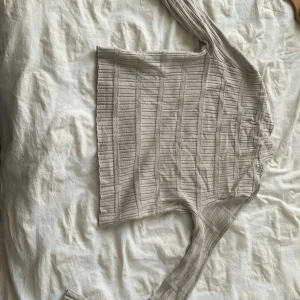 Beige ribbad croppad tröja BikBok - Säljer en beige ribbad croppad tröja från BikBok i storlek XS. Tröjan har lång ärm, tight passform och är tillverkad i mjukt stickat material. Perfekt till jeans eller kjol för en chill och snygg look.