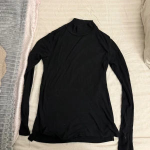 Svart polotröja med lång ärm - En svart polotröja med lång ärm och enkel, Tröjan är ribbad