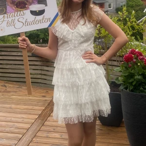 Supersöt studentklänning med volang - Supersöt vit studentklänning från Bubbleroom med flera lager volanger och transparent spets upptill. Nypris är 899kr. Använd 1 gång, på min studentdag☺️💕 Storleken på lappen är XS men skulle säga att den är mer åt S hållet eller 36.
