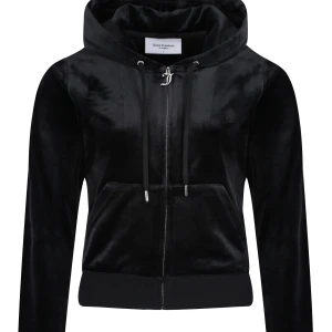 Svart velour hoodie från Juicy Couture - Säljer en svart hoodie från Juicy Couture i mjuk velour med dragkedja framtill, huva och snörning. Klassisk känguruficka och diskret JC-logga på bröstet. Perfekt för en chill och trendig look.