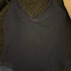 Linne med spets - Snygg mörkblå linnetopp med smala axelband och v-ringning dekorerad med spets. Fint skick