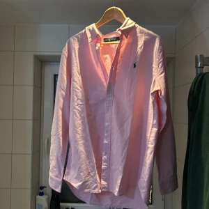 Rosa skjorta Ralph Lauren  - Säljer en klassisk rosa skjorta från Ralph Lauren med broderad logga på bröstet. Skjortan är endast testad på men passa ej mig i stilen. Säljs för mycket mindre än inköptspriset. Hör av er vid minsta intresse💸
