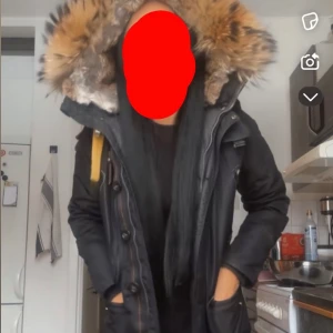 Svart Parajumpers parkas med päls - Säljer nu min Parajumpers jacka då jag köpt en annan. Masterpiece serien, slim fit med stor fluffig päls runt huvan och snygga detaljer som gul rem och broderad logga på ärmen. Jackan har flera fickor, dragkedja och knappar framtill. Korta modellen. Enda skavankerna som finns är slitningar på dom små detaljerna som även syns på bilderna, annars är jackan i jättefint skick. Storlek XS.