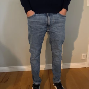 Blå jeans från Nudie Jeans W30 L30 - Säljer ett par blå jeans från Nudie Jeans i storlek W30 L30. Modellen är 177cm och väger runt 60kg