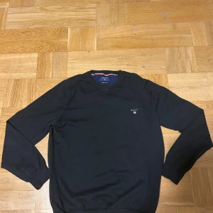 Svart bomullströja från GANT - Säljer en snygg svart tröja från Gant. Storlek S, jag är 183 och sitter bra bara lite kort i armarna för mig, väldigt bra skick, använd bara ett fåtal gånger. Passar till nästintill allt, bara att höra av er vid frågor