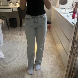 Ljusblå raka jeans med fransad kant - Säljer ett par ljusblå jeans med raka ben och fransad kant nertill. Jeansen har klassisk femficksdesign och hög midja. Perfekta för dig som gillar en avslappnad och stilren look.