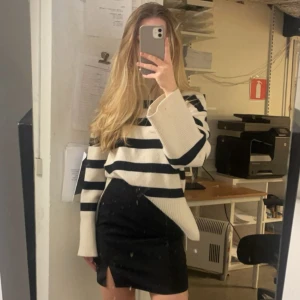 Stickad tröja  - Snygg polotröja från BikBok i storlek XS. Tröjan är vit med breda svarta ränder, har lång ärm och hög ribbad krage. Den är stickad och har en loose fit med breda muddar nertill och vid ärmslut. Perfekt för höst och vinter!