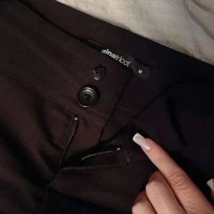 Svarta kostymbyxor - Svarta kostymbyxor från Gina Tricot i M, två knappar en som är halv! och dragkedja framtill samt fickor med knapp bak. Sitter skitsnyggt och dom är kolsvarta det blev konstigt på bilden bara!!💓