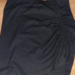 Midkort kjol från H&M - En fin kort kjol från H&M men en skrynkligt snitt ena sidan av benet. Säljer eftersom den är lite för stor på mig. Den når ner till mina knän ungefär men man kan alltid vicka upp den vid midjan föratt göra den lite kortare! Den är ca 40cm i längd o kan även användas som en tube topp också🥰