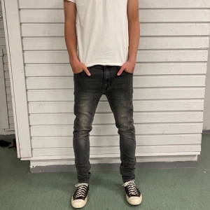 Grå jeans från Weekday Friday Dusk - Säljer ett par gråa jeans från Weekday i modellen Friday Dusk Grey. Jeansen har klassisk femficksdesign, raka ben och är tillverkade i stretchig denim av 98% bomull och 2% elastan. Perfekta för en chill och stilren look.