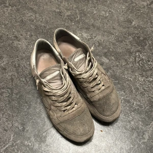 Philippe modell slitna - Säljer ett par beige sneakers med ovandel i mocka och detaljer i skinn. Skorna har snörning och platt sula, samt rund tå. Perfekta för dig som gillar en neutral och stilren look till vardags. Klassisk sneakerstil med diskreta sömmar och paneler. Säljer dessa Philippe model som är väldigt slitna och smutsiga, använda mycket och smutsen är från en festival. Vill bara bli av med dom.