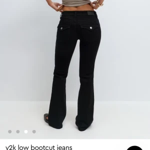 Svarta low waist bootcut jeans - Snygga svarta bootcut jeans med låg midja och klassisk femficksdesign. Jeansen har silverfärgade knappar och detaljer, samt lätt utsvängda ben för en retroinspirerad look. Perfekta för dig som gillar Y2K-stil och vill ha en cool siluett.