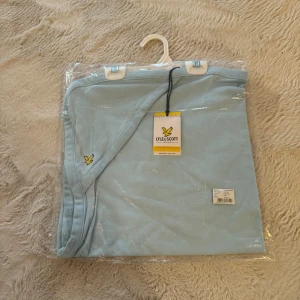 Ljusblå babyfilt från Lyle & Scott - Mjuk och fin babyfilt från Lyle & Scott Junior. I färg Vintage Grey Heather / Navy Blazer / angel falls, ljusblå. Tillverkad i 100% ekologisk bomull. Mysig filt att ha hemma eller i vagnen.   Storlek: 0–3 månader (One size).  🌟 HELT NY fortfarande i originalförpackning med tag kvar. 🌟  Finns i fler färger, kolla mina annonser eller skriv meddelande.