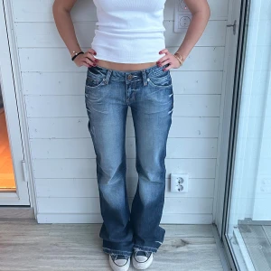 Blå bootcut jeans  - Blå bootcutjeans i unik tvätt och coola bakfickor. Storlek XS-S, Midja: 37x2 cm innerben: 86 cm