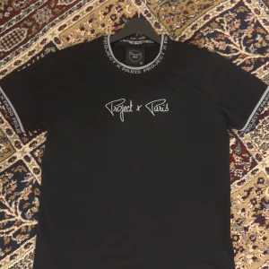 Svart Project X Paris t-shirt - En riktig snygg Project X Paris T-shirt som har använts väldigt sparsamt och fint. Säljer denna då den blivit lite för stor för mig. Har använts som sagt, men väldigt sparsamt.   Har du några funderingar eller vill ha fler bilder, tveka inte att fråga!